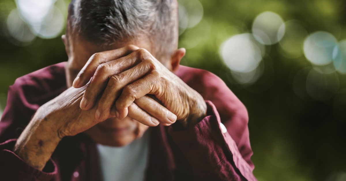 senior man covering his face
