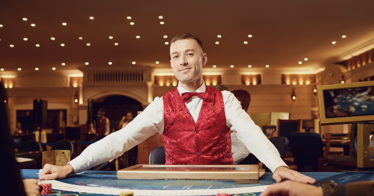 male croupier holding poker cards 