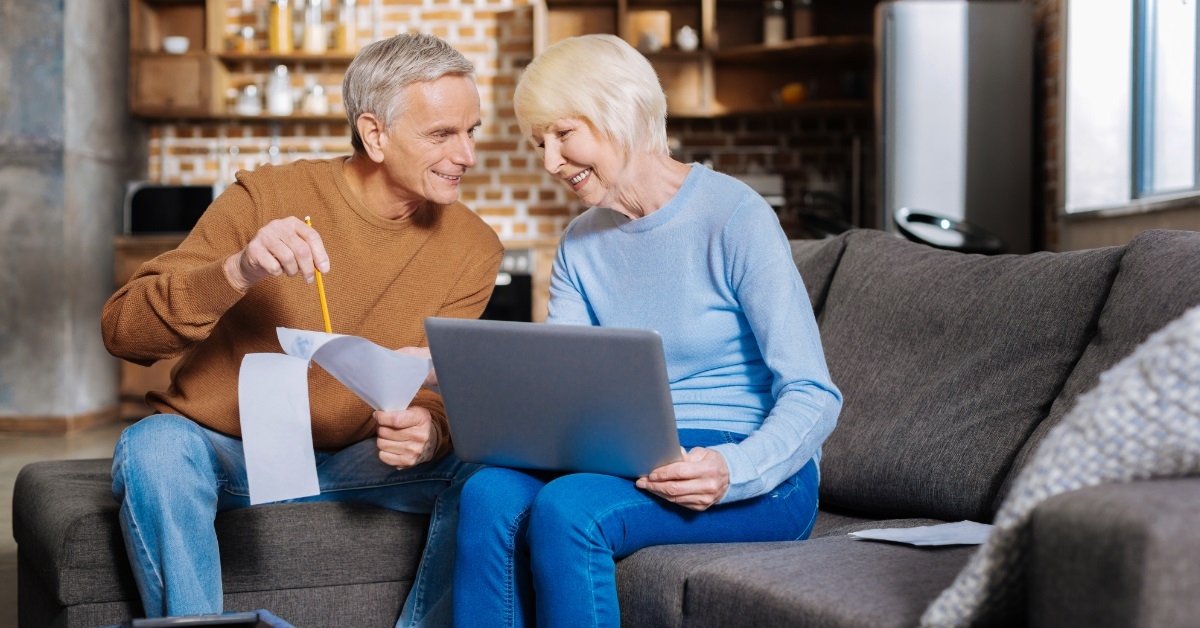 happy senior couple reviewing bills together