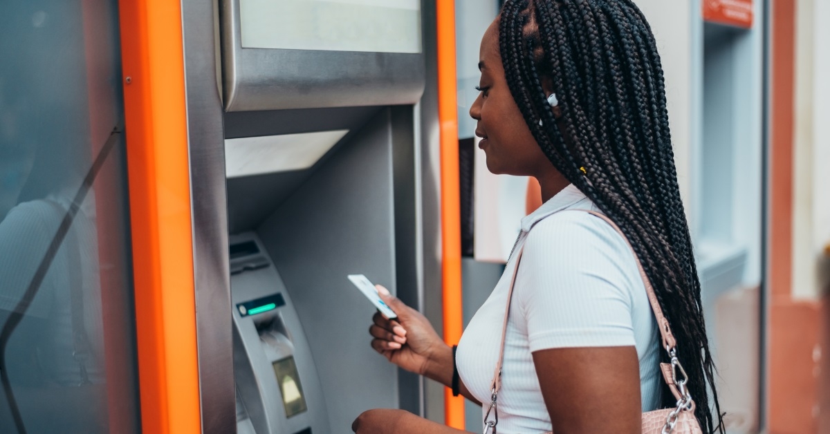 african american woman besides atm machine