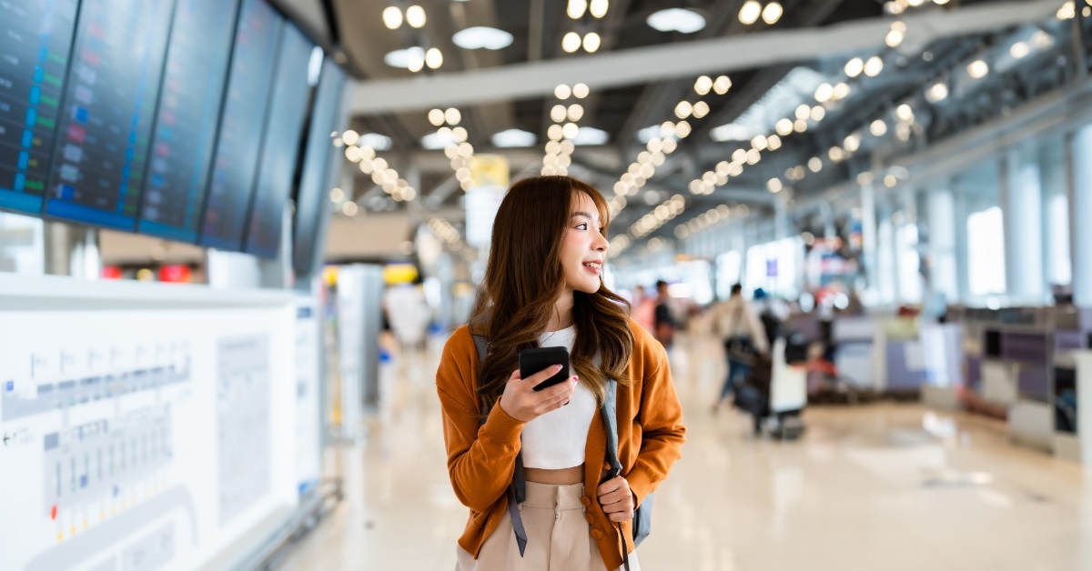 asian woman using mobile at airport
