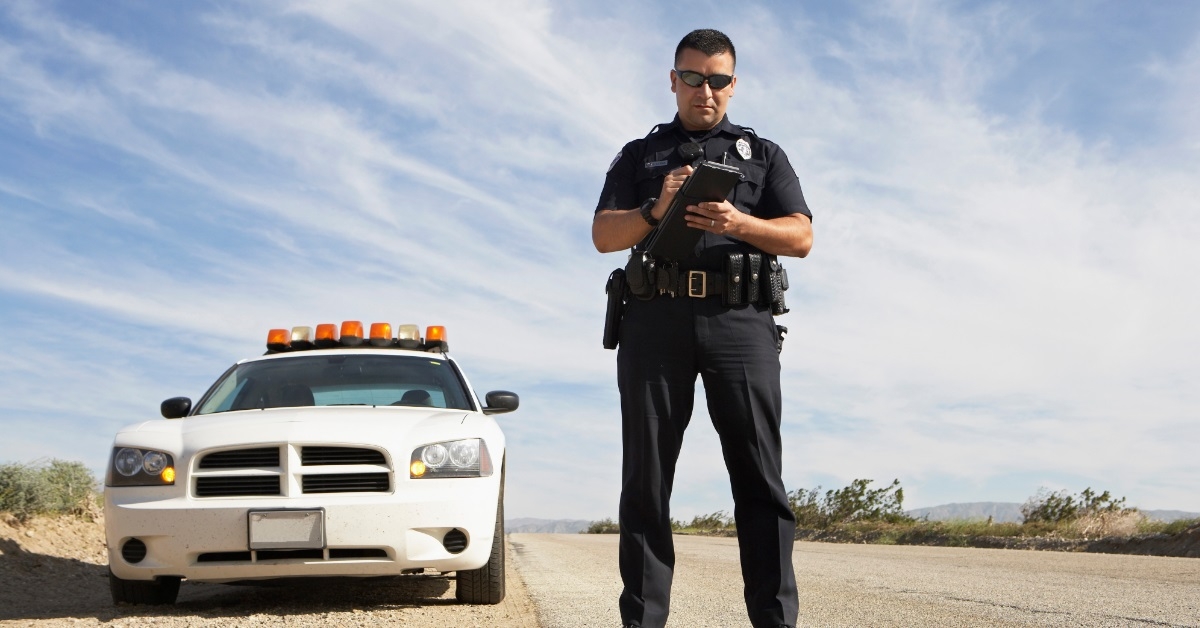 handsome policeman writing on clipboard