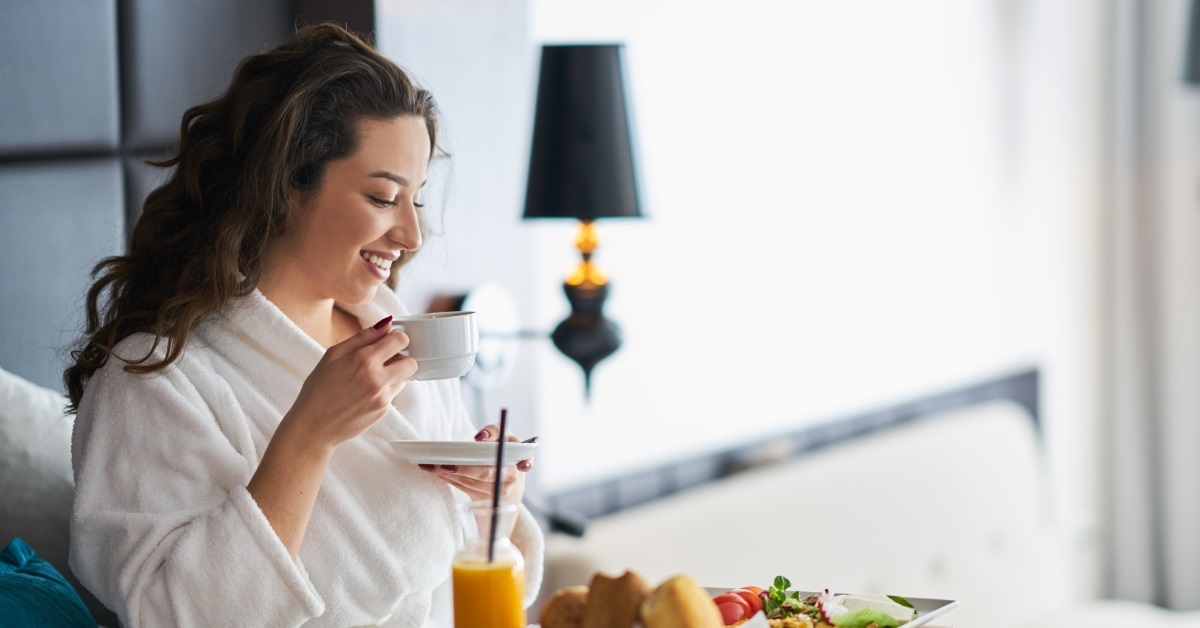 woman enjoying breakfast in bed