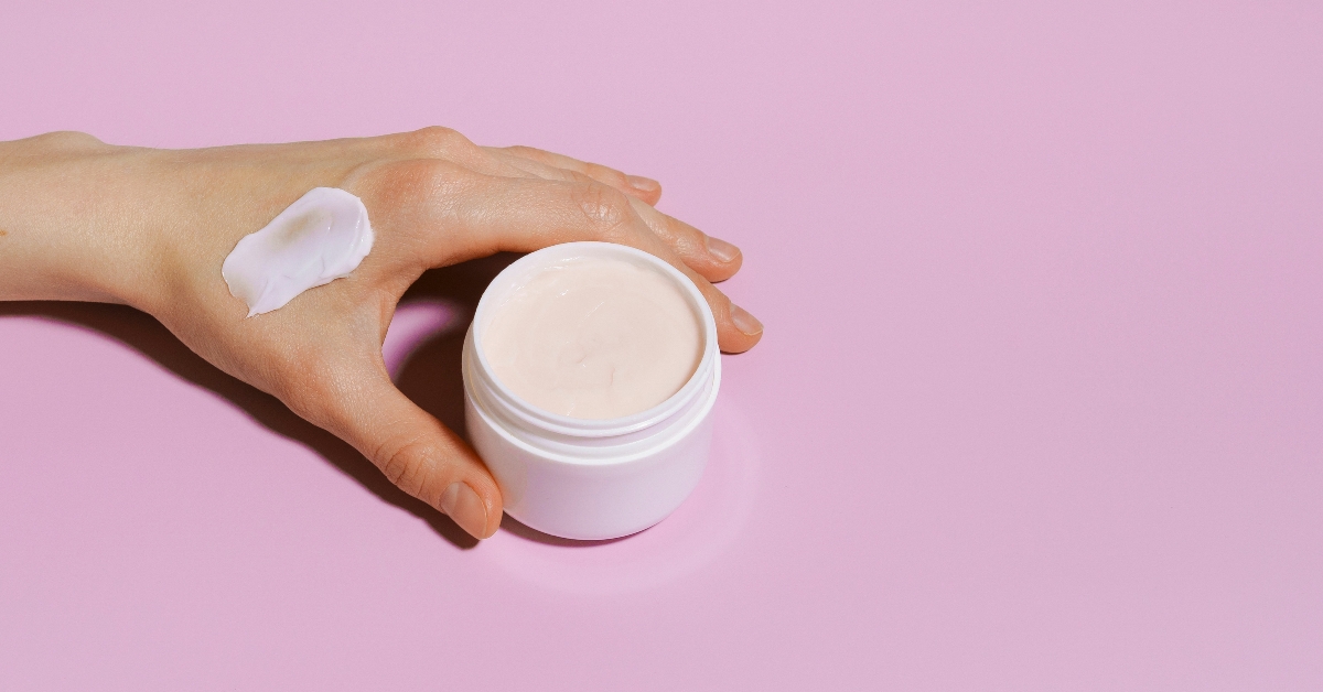hand with a smear of pink face cream