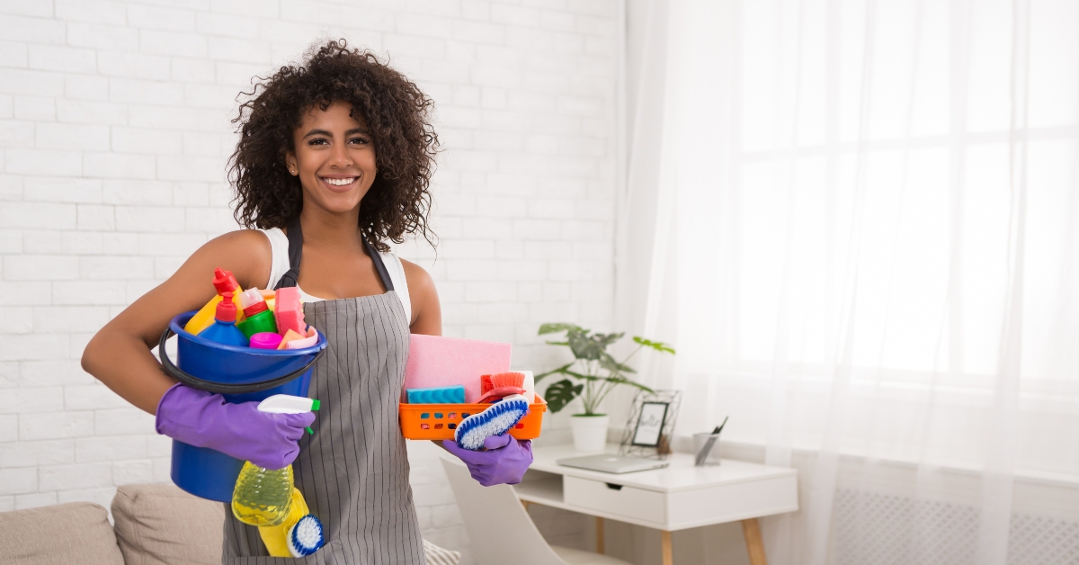 woman posing with cleaning supplies