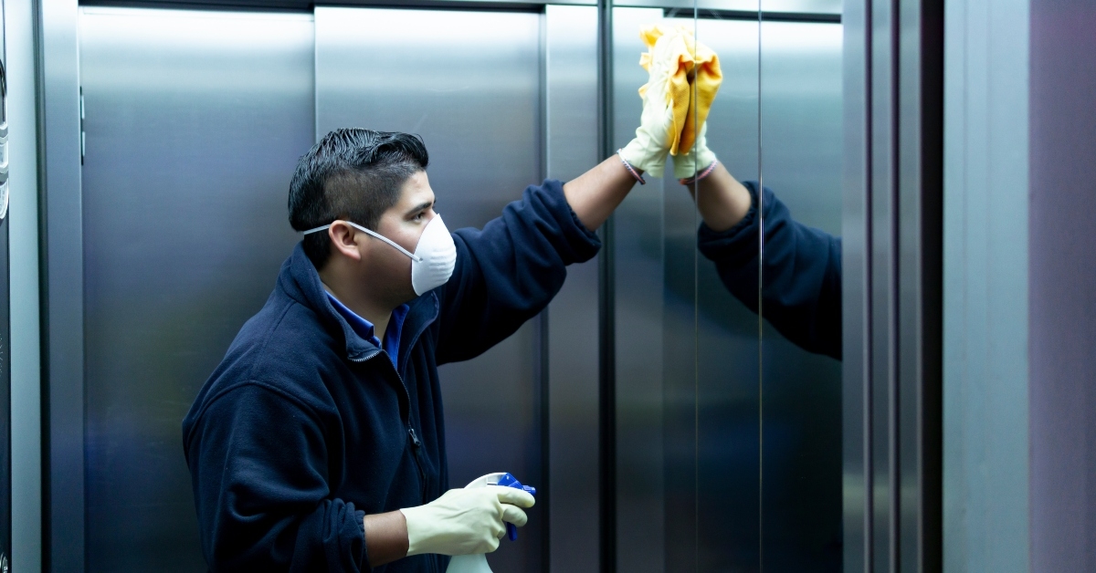 cleaning staff disinfecting elevator