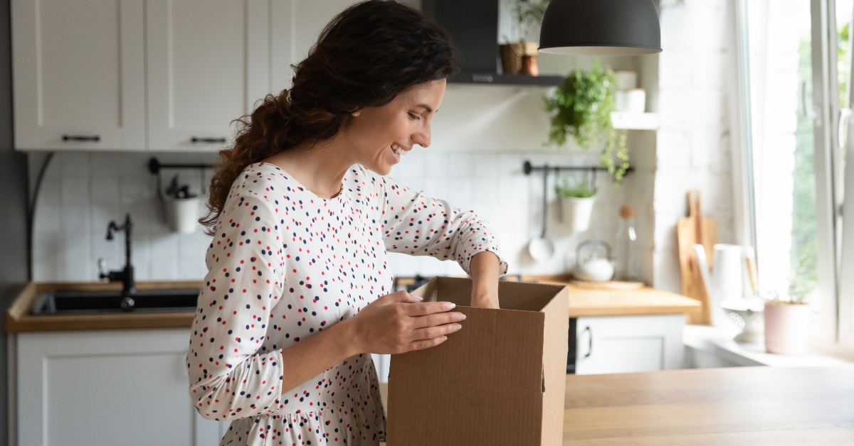 woman opening box in kitchen