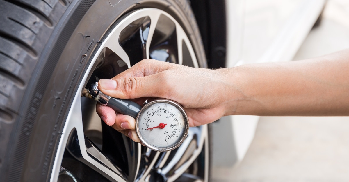 hand checking tyre pressure using equipment