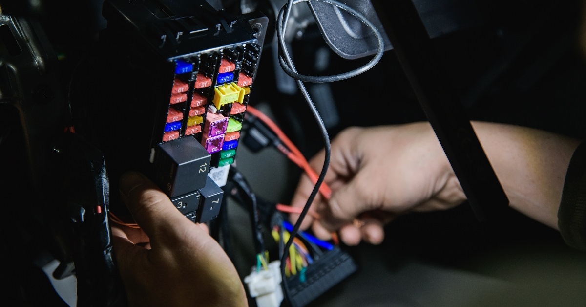 mechanic repairing car fuse box