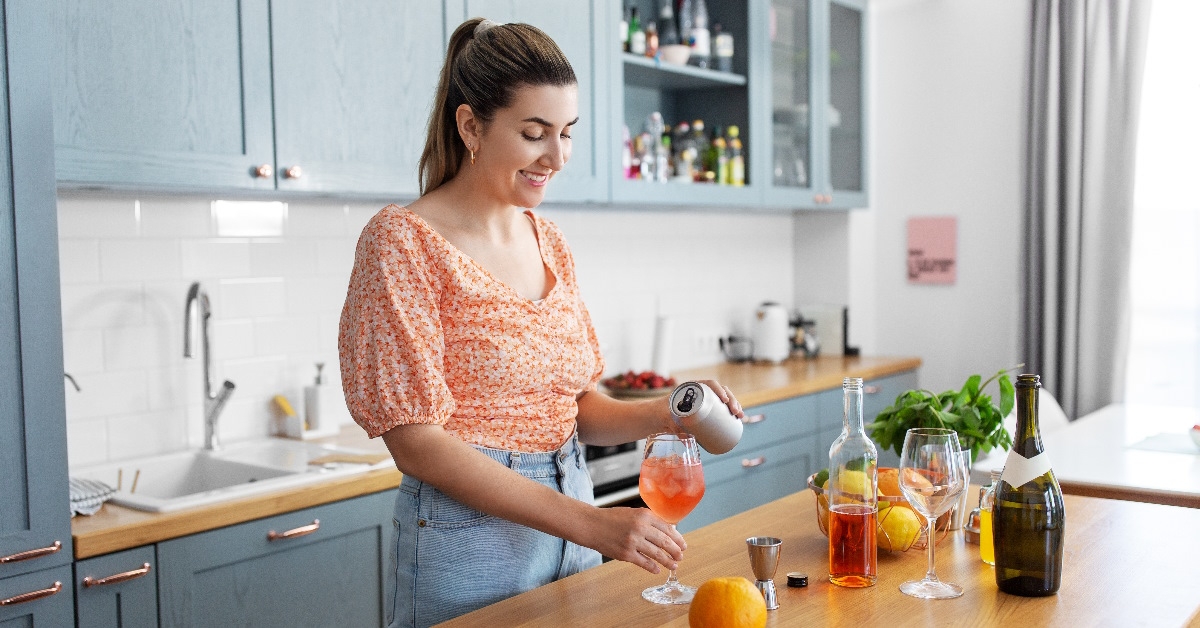 woman making orange cocktail at home