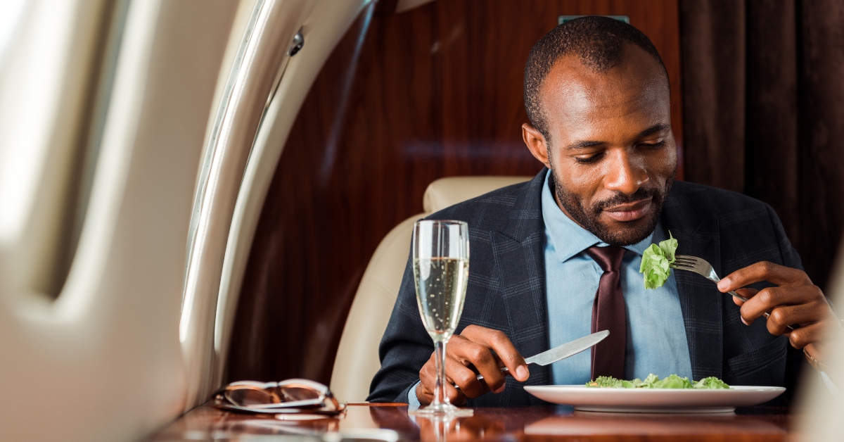 businessman eating salad in private jet