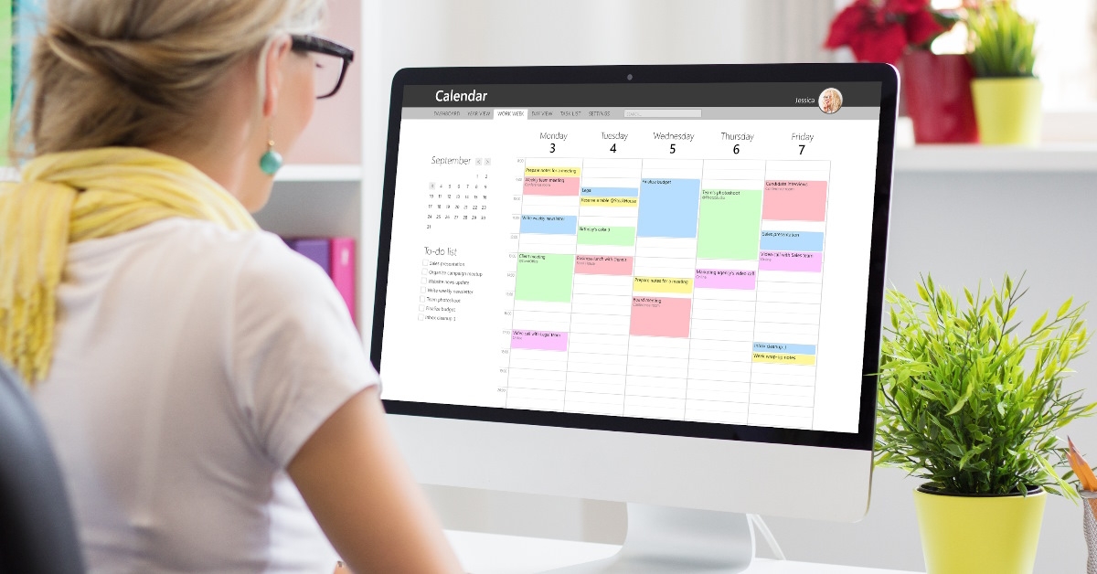 Woman using calendar on office computer