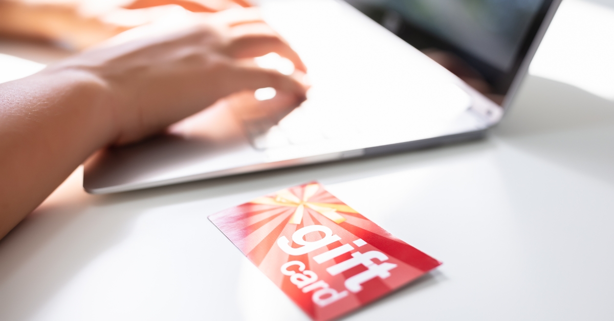 gift card on desk near laptop