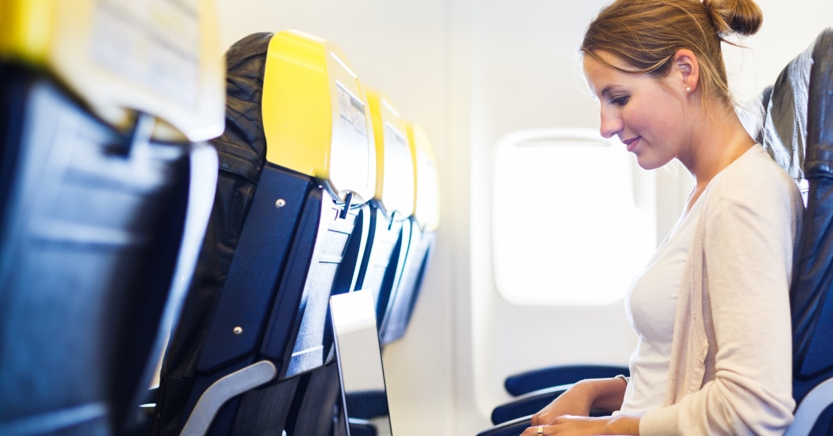 business woman using laptop on airplane