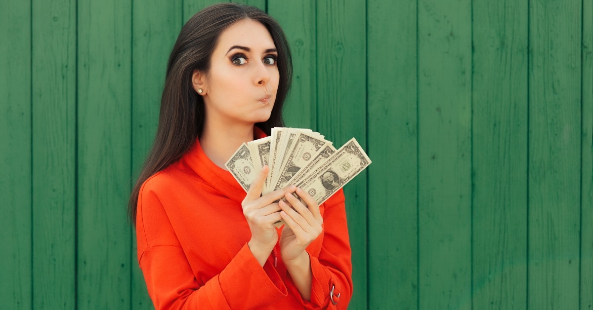 woman flaunting banknotes on green backdrop