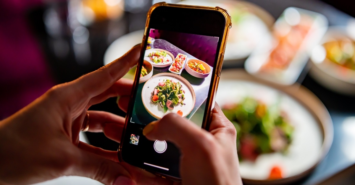 hand photographing food at restaurant