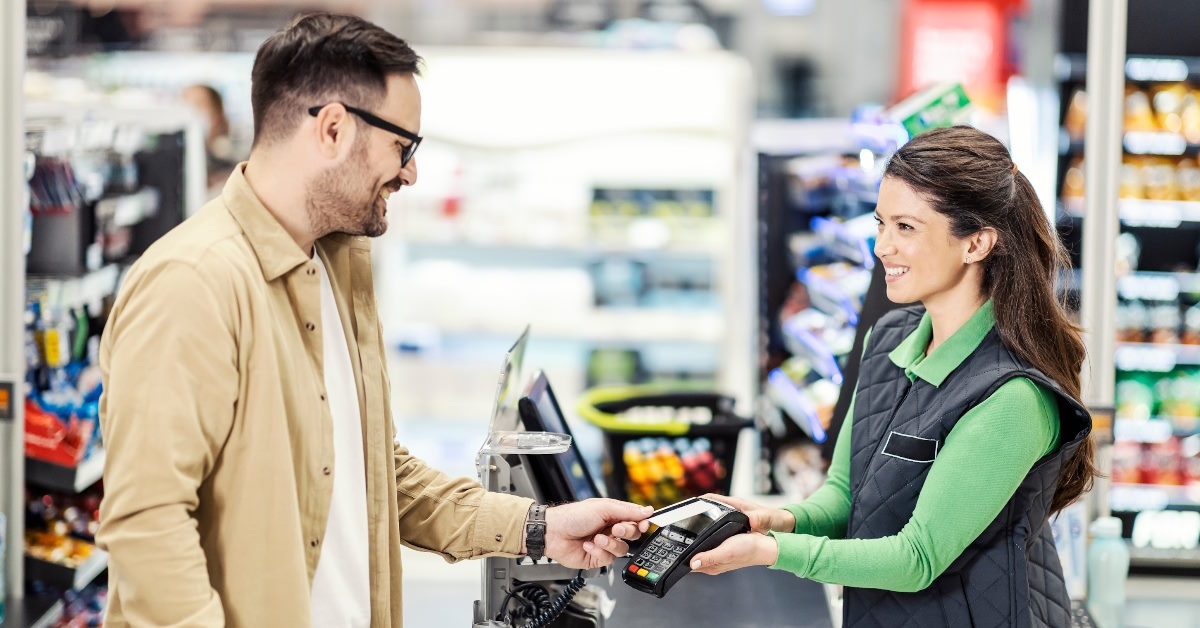 customer paying at checkout in supermarket