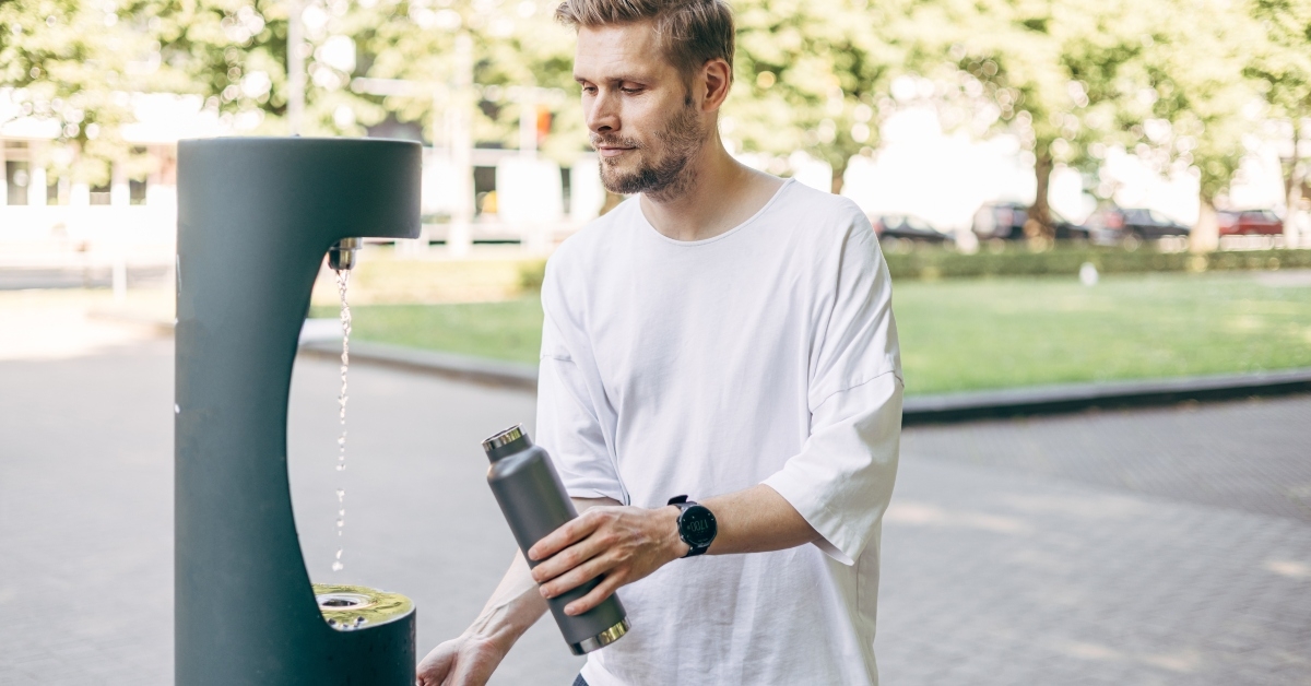 man refilling his water bottle
