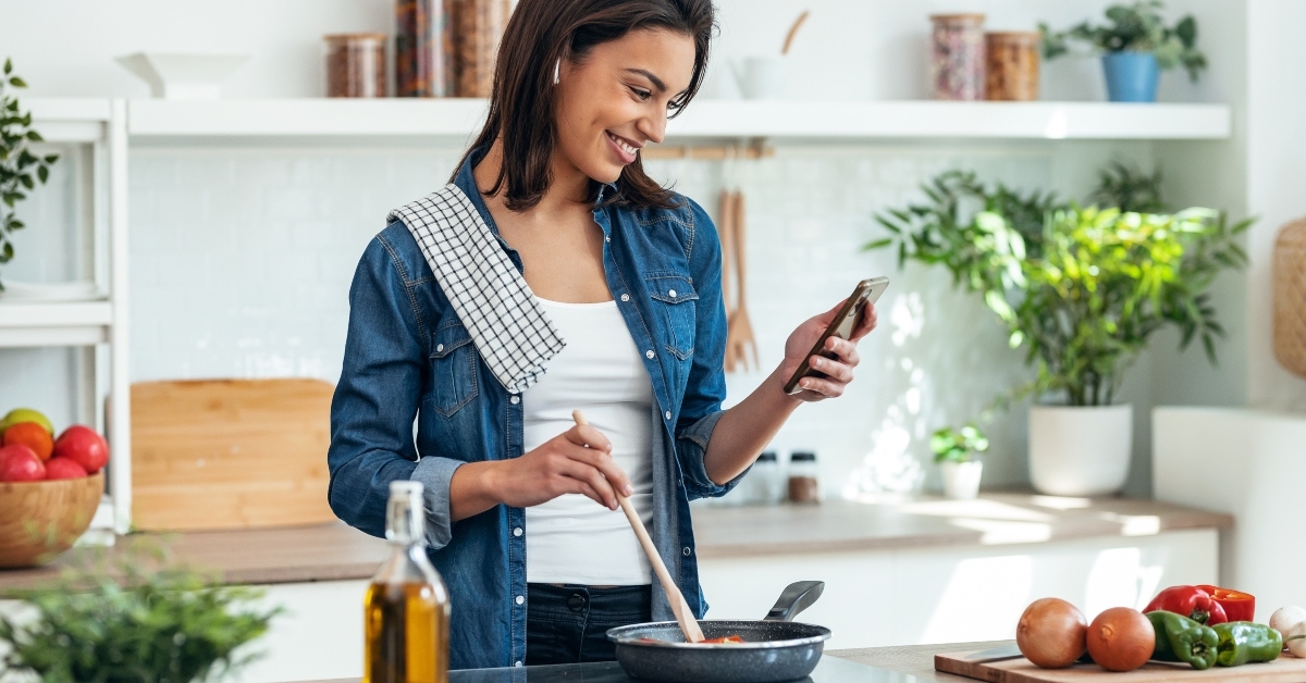 woman cooking while using phone