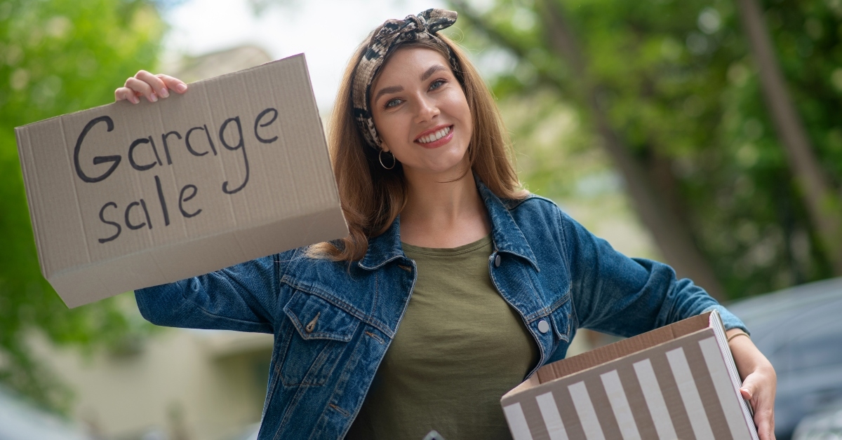 woman holding a garage sale sign