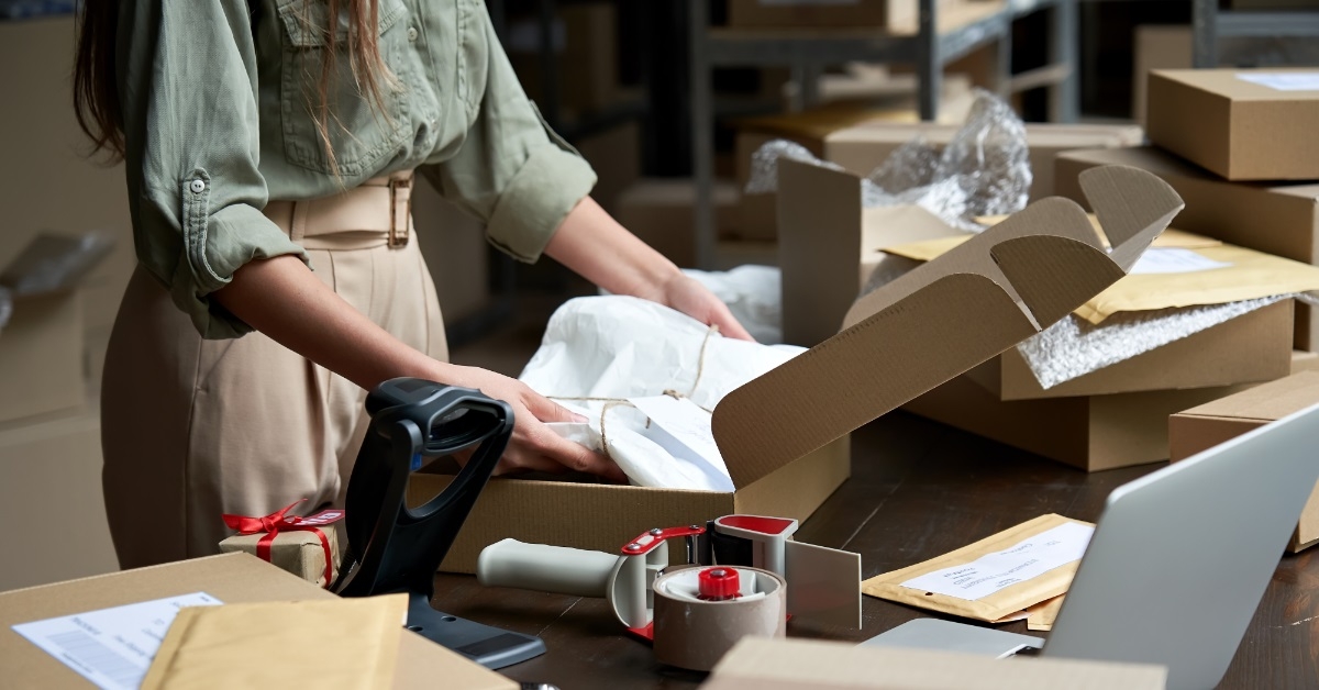 woman packing customer parcels before shipping