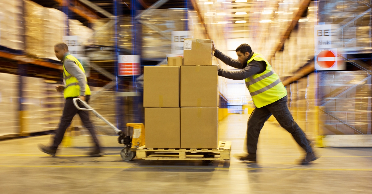 workers carting boxes in warehouse