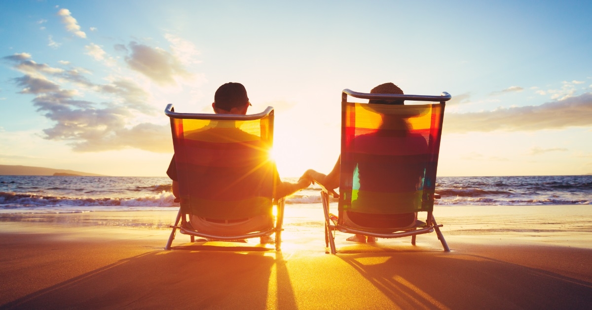 mature couple watching sunset at beach