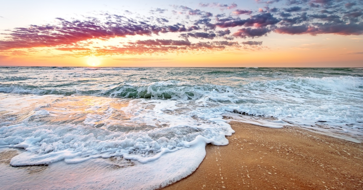 waves at beach with colorful sky