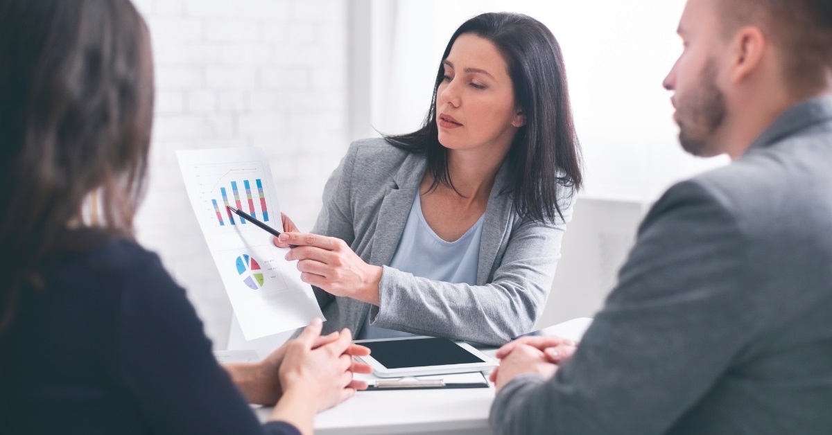 female broker showing data to couple
