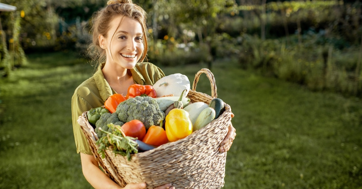 woman holding vegetable basket in garden