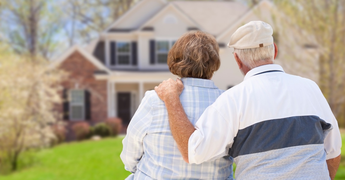 retired couple sitting outside new house