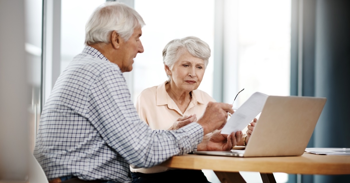 focused senior couple reviewing bills together