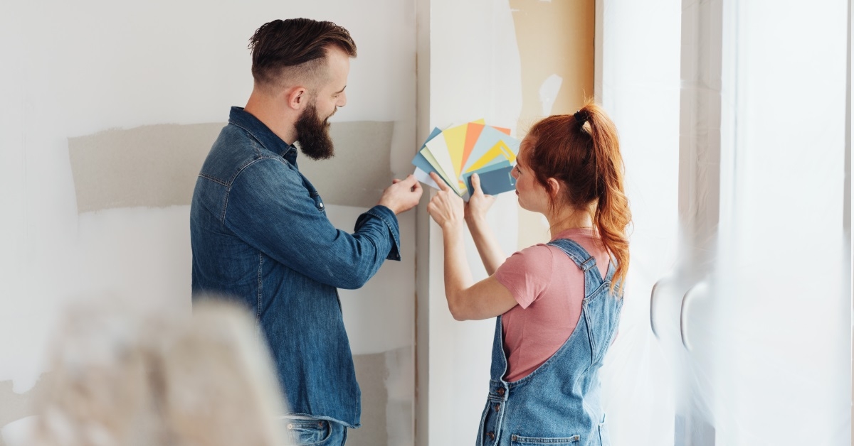 couple trying color swatches for wall