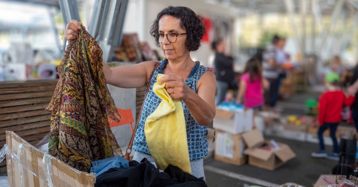 woman checking clothes at garage sale