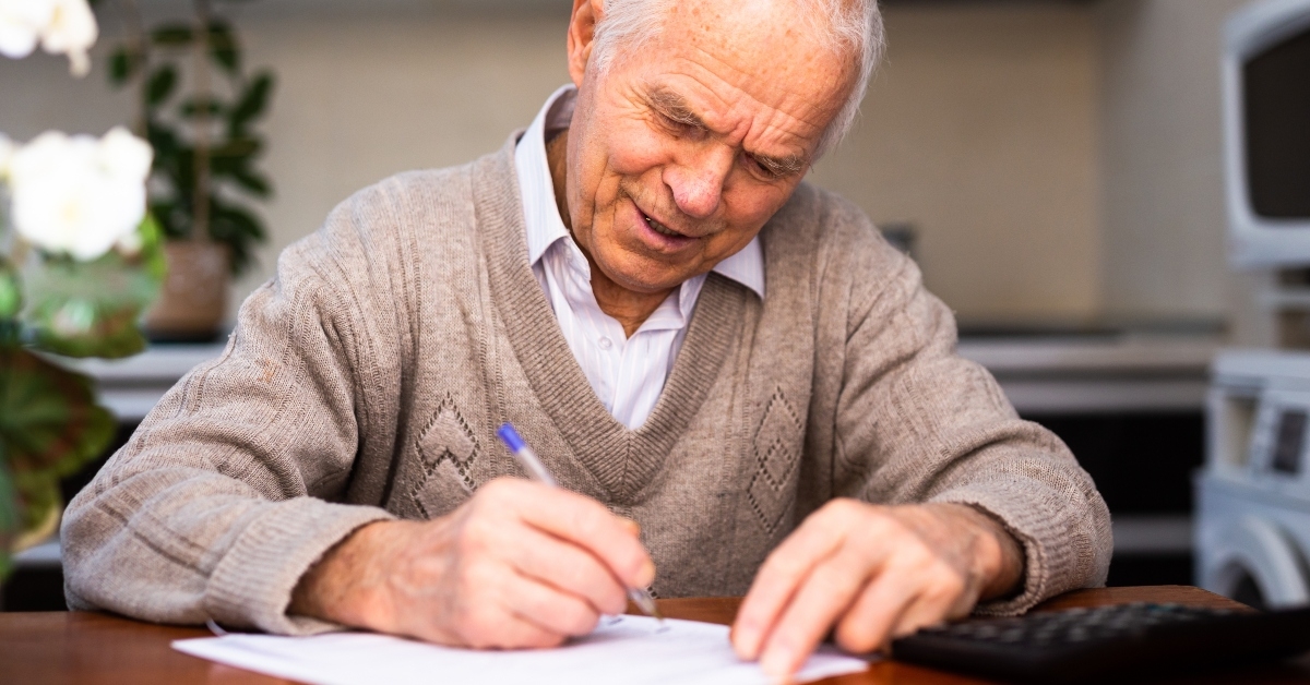 pensioner writing on piece of paper