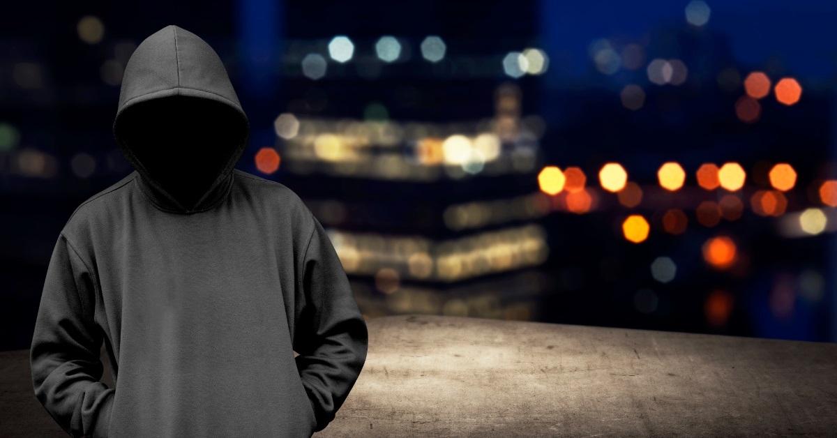 faceless man in hood on rooftop