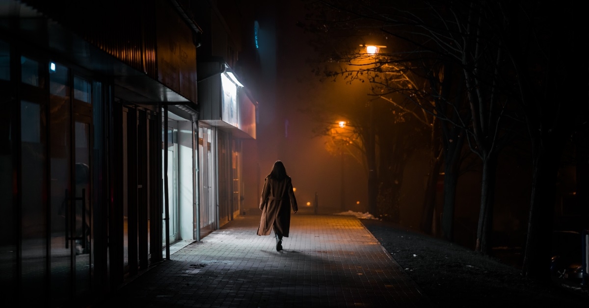 woman walking alone on dark street