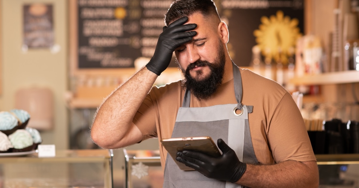 unhappy barista using tablet at cafe