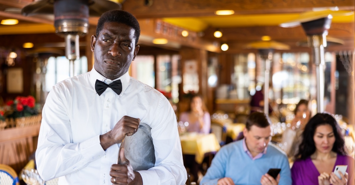 african american waiter unhappy at restaurant