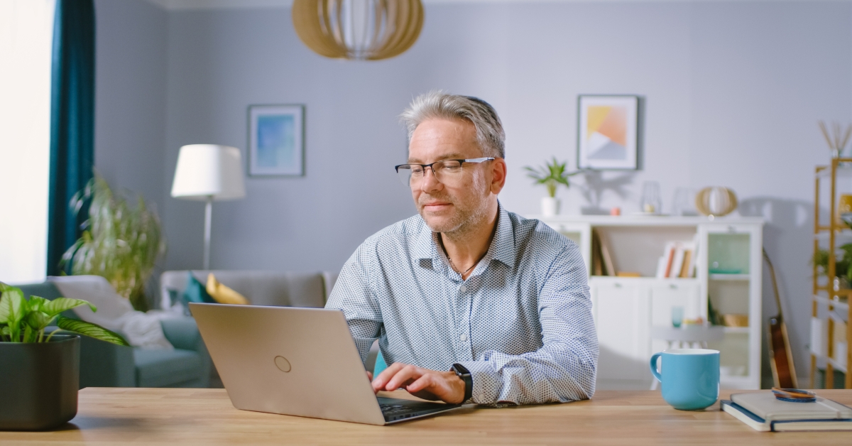 middle aged man uses laptop