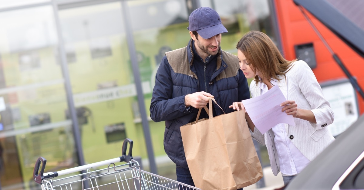 couple checking grocery bag outside store