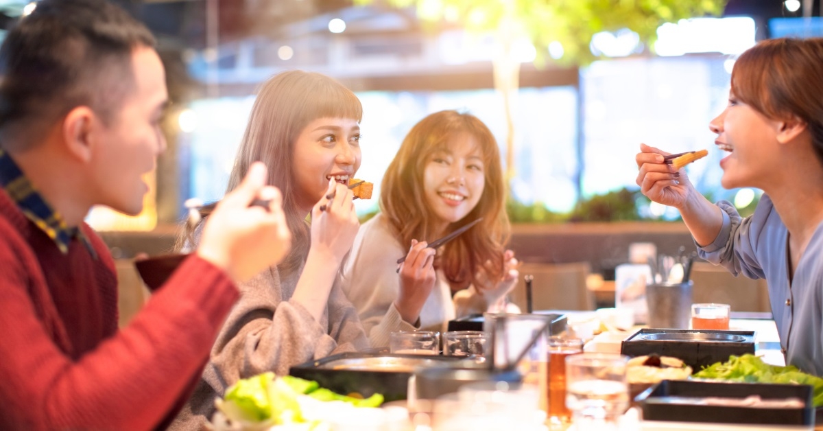 asian friends enjoying lunch at restaurant