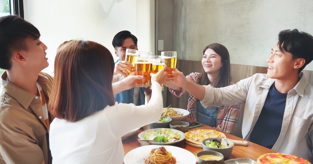 asian friends toasting beer at restaurant