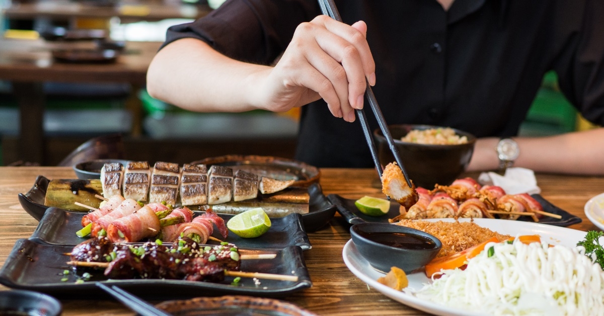 woman eating sashimi in asian restaurant
