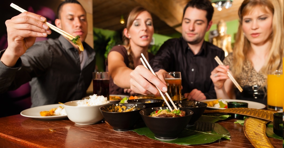 young friends eating at thai restaurant