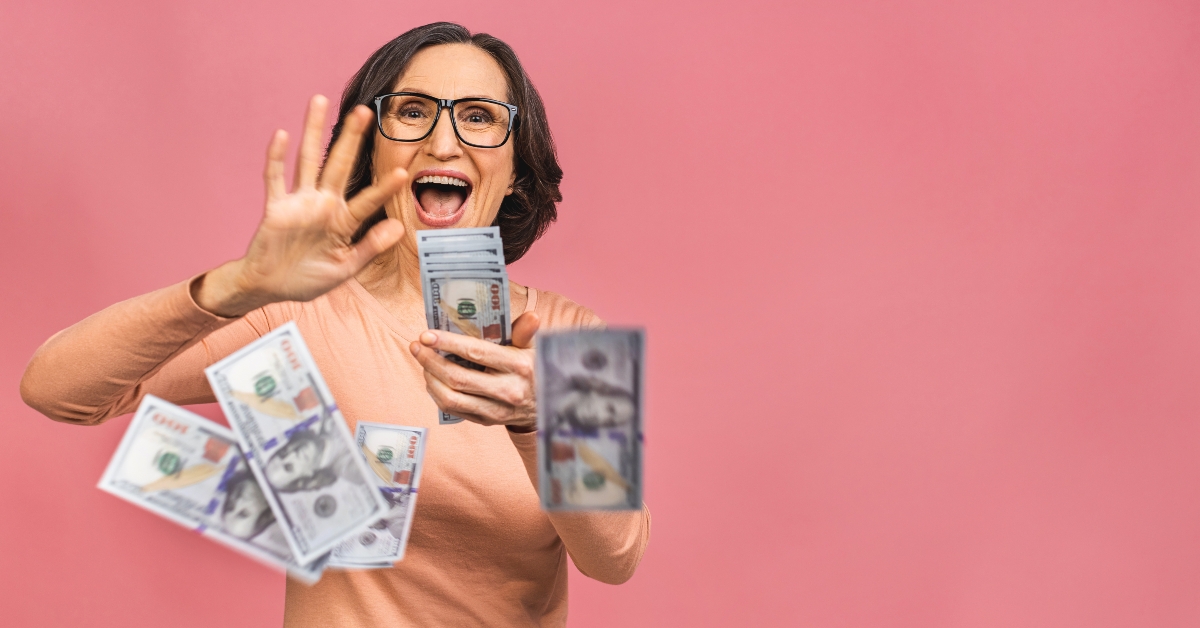 happy senior woman holding money