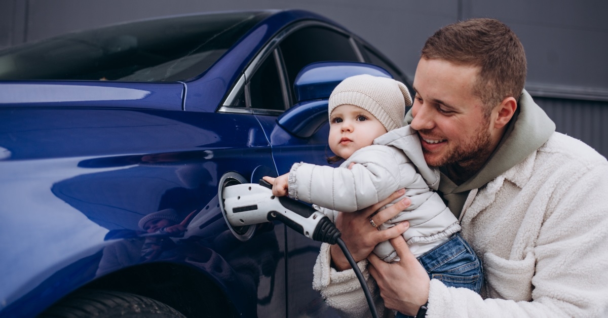 father and daughter besides electric vehicle