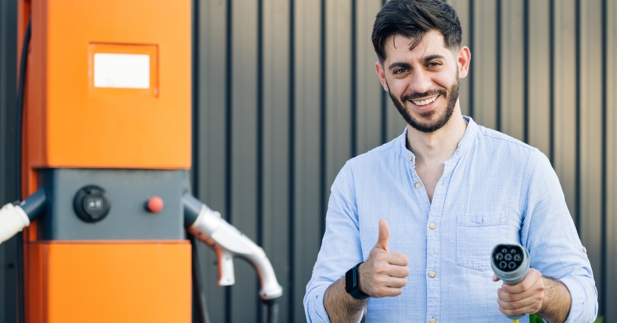 satisfied man at car charging station
