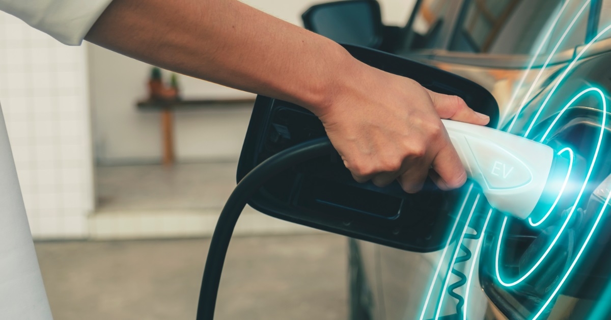 man using cable to charge car