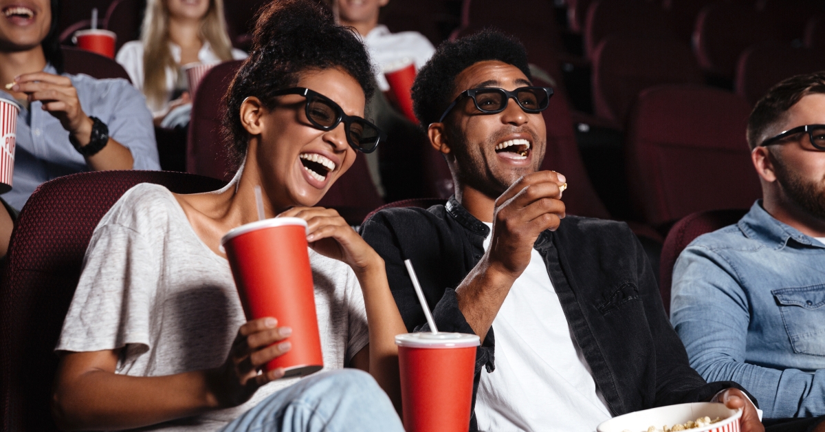 happy friends sitting in cinema